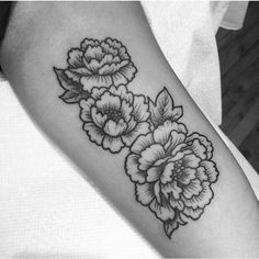 a black and white flower tattoo on the arm