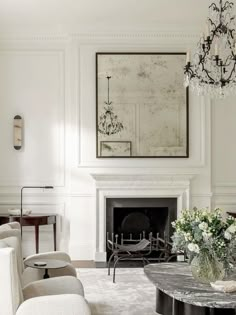 a living room filled with furniture and a chandelier above a fire place in front of a fireplace