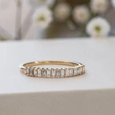 a gold ring with baguettes on it sitting on top of a white box