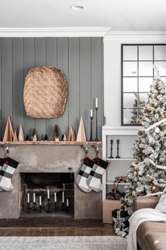 a living room decorated for christmas with stockings hanging from the fireplace and decorations on the mantle