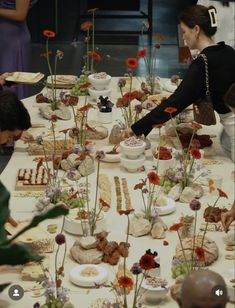 a table topped with lots of different types of food and flowers on top of it