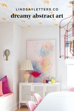 a dining room with pink chairs and a painting on the wall above it that reads lindsay letters