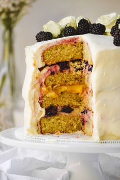 a cake with white frosting and blackberries on top