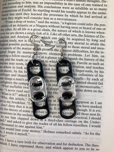 two pairs of black and silver handcuffs are on top of an open page of a book