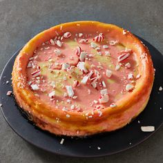 a cake with candy canes on top is sitting on a black plate, ready to be eaten