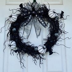 a wreath with black and white decorations hanging on a door