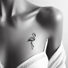 a black and white photo of a woman with a flamingo tattoo on her chest