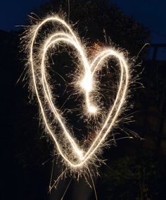 a heart made out of sparklers in the dark