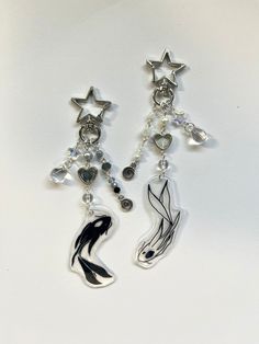 two silver earrings with black and white designs hanging from the ends of each dangle