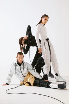 three models in white and black outfits posing for the camera