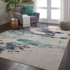 a living room area with a chair, rug and potted plant on the floor