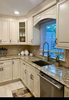 a kitchen with white cabinets and granite counter tops