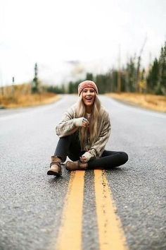 a woman sitting on the side of a road