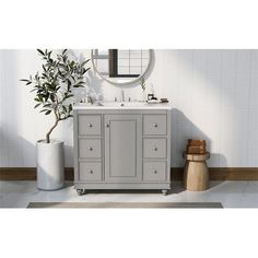 a white sink sitting under a mirror next to a potted plant and wooden stool