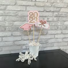 a graduation cake topper sitting on top of a bucket filled with marshmallows