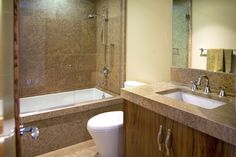 a bathroom with a sink, toilet and bathtub next to a shower stall in the corner