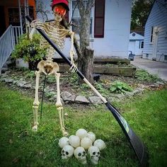 a skeleton with a broom and some balls in the grass