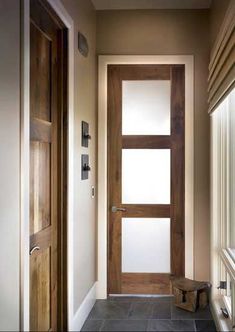 an empty hallway with a wooden door and window