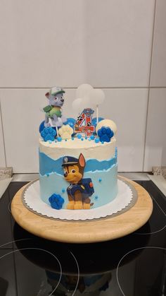 a birthday cake decorated with an image of a dog on the front and blue frosting