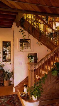 a living room filled with lots of plants next to a wooden stair case covered in potted plants