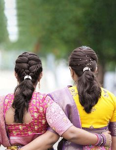 two women in colorful saris walking down the street with their backs to each other