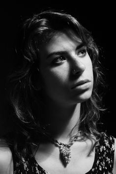 a black and white photo of a woman wearing a necklace