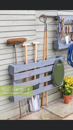 a garden tool rack with gardening tools hanging on it