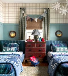 two twin beds in a bedroom with blue walls and plaid bedding on the covers