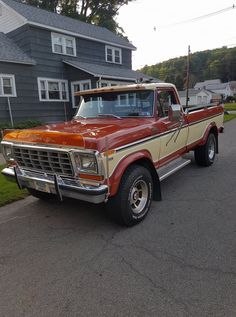 an orange and white truck parked in front of a house