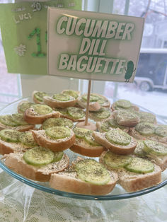 there is a plate full of sandwiches on the table with a sign that says cucumber dill baguette