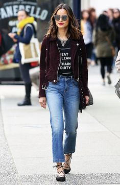 a woman walking down the street wearing jeans