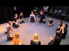 group of people sitting in a circle on the floor with their hands up to each other