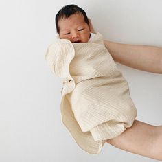 a baby wrapped in a blanket is being held up