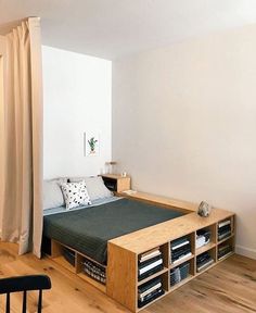 a bed sitting in the middle of a bedroom next to a wooden table and chair