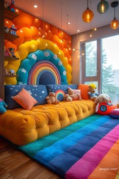 a rainbow themed living room with lots of pillows and stuffed animals on the couches