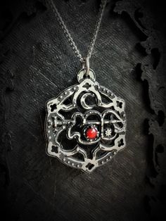 The Clauneck Seal Pendant with Gothic Ornaments is a handcrafted piece made from fine pewter, containing 98% tin, featuring an intricate design that showcases the Seal of Clauneck adorned with elegant gothic embellishments. This pendant measures 3 cm in diameter and is enhanced with a gemstone of your choice, allowing for personalization and individual expression. It comes with a choice of a stainless steel chain in either 18 or 24 inches, ensuring durability and hypoallergenic properties. The S Ornate Bronze Oxidized Jewelry, Ornate Oxidized Bronze Jewelry, Silver Pewter Jewelry Gift, Engraved Gunmetal Jewelry As Gift, Engraved Gunmetal Jewelry For Gifts, Engraved Pewter Jewelry Gift, Adjustable Antique Silver Jewelry, Antique Silver Pewter Spiritual Jewelry, Silver Filigree Symbolic Jewelry