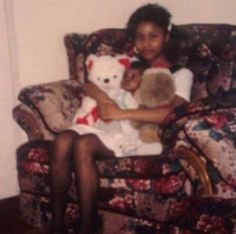 a woman sitting in a chair holding two teddy bears