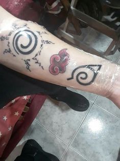 a person with a tattoo on their arm that has the letter s and is surrounded by flowers