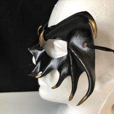 DESCRIPTIONMystify the mortals at the Halloween masquerade with a gold-tipped, black leather vampire mask! Perfect for masquerade parties or theatre productions. Get this gold-tipped mask for Halloween or Vampire Masquerade. A sexy costume accessory for your vampire costume, and a fantastic festival mask! Add to a RenFaire costume. Any color. Waterproofed leather, glossy or matte finish, & several choices to affix the mask (cord, elastic, ribbon, waterproof cord, stick, or no holes for adhesive) Black Gothic Masks For Fantasy Events, Halloween Theater Mask, Phantom Masquerade Mask For Halloween, Gothic Masks And Prosthetics For Mardi Gras Cosplay, Phantom Color Masquerade Mask For Halloween, Halloween Masquerade Mask In Phantom Color, Halloween Fantasy Eye Masks And Prosthetics, Halloween Eye Mask For Fantasy Events, Halloween Fantasy Eye Mask