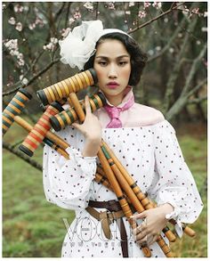 a woman in white dress holding wooden poles