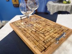 two wine glasses sitting on top of a wooden tray