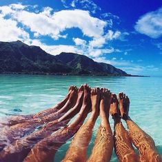 two people are laying in the water with their feet up on each other's legs