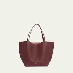 Mansur Gavriel tote bag in soft calf leather Flat shoulder straps  Open top with self-tie closure  Interior, leashed zip pouch bag Approx. 11.8"H x 21.5"W x 9"D Made in Italy Smooth Grain Crossbody Bag For Shopping, Shopping Satchel With Smooth Grain And Double Handle, Shopping Smooth Grain Satchel With Double Handle, Daily Double Handle Smooth Grain Shoulder Bag, Calf Leather Shoulder Bag With Double Handle For Everyday, Everyday Calf Leather Shoulder Bag With Double Handle, Everyday Double Handle Calf Leather Shoulder Bag, Daily Use Smooth Grain Calf Leather Shoulder Bag, Daily Use Calf Leather Shoulder Bag With Smooth Grain