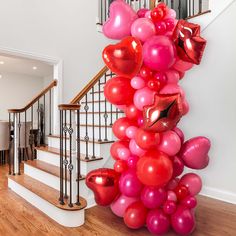 a bunch of balloons that are on the ground in front of a stair case and some stairs