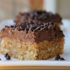 a close up of a piece of cake on a plate with chocolate chips and coconut