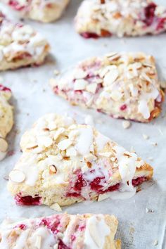 cookies with white icing and cranberry toppings are on a baking sheet