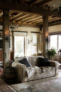 a living room filled with furniture and lots of wooden beams on the ceiling above it