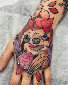 a person's hand with a tattoo on it and a slotty holding flowers