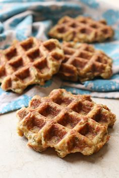 three waffles sitting on top of a table next to a blue cloth and napkin