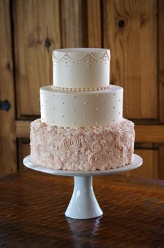 a three tiered wedding cake sitting on top of a table